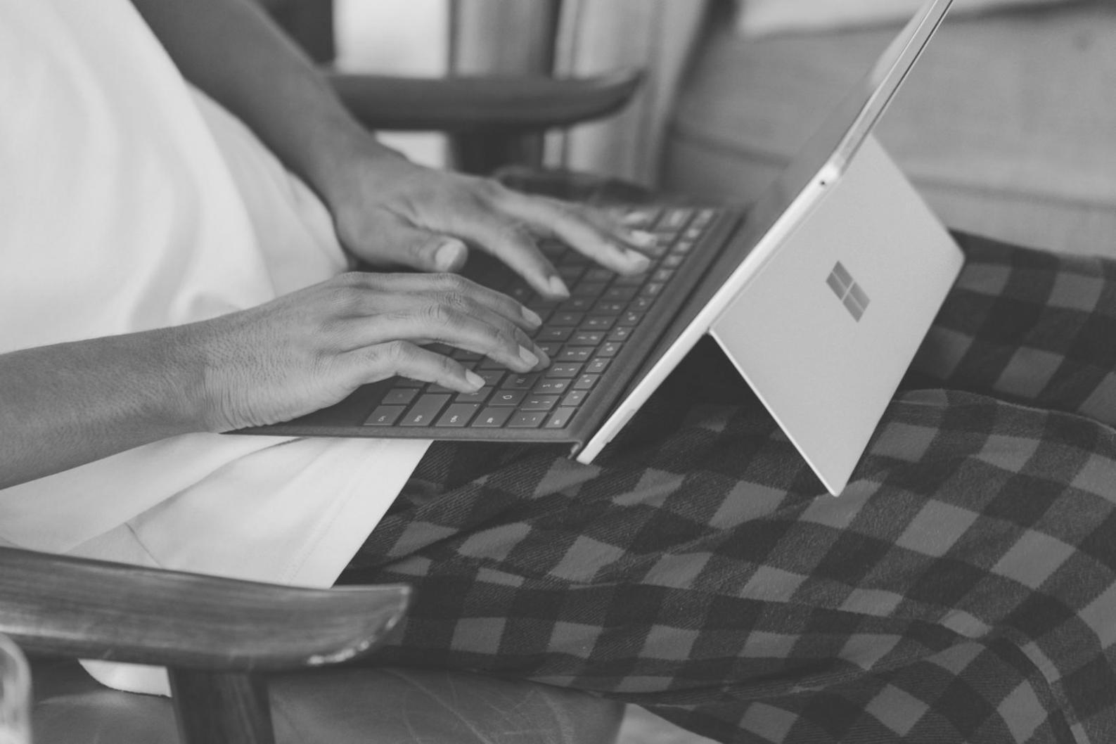 Mani che compilano documentazione finanziaria con laptop e grafici